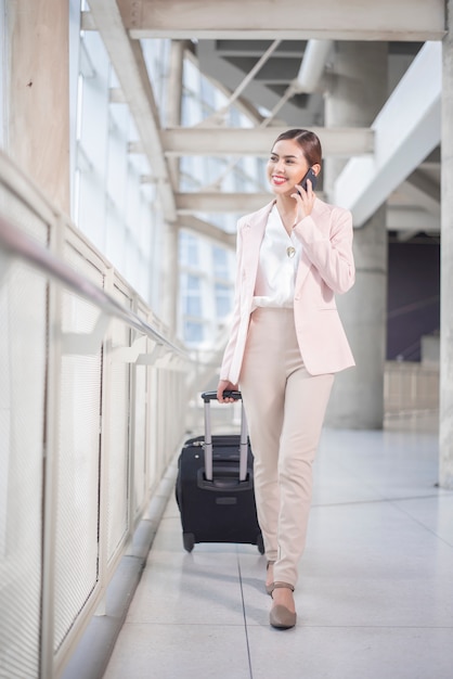 Mulher de negócios bonita está andando no aeroporto, conceito de viagens de negócios