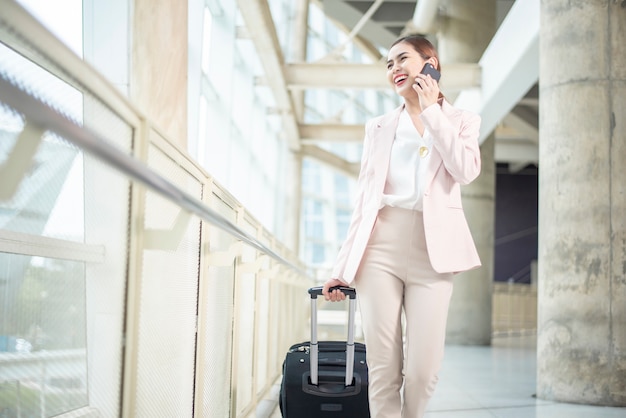 Mulher de negócios bonita está andando no aeroporto