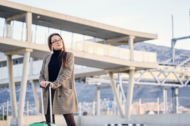 Mulher de negócios bonita jovem no aeroporto internacional com mala