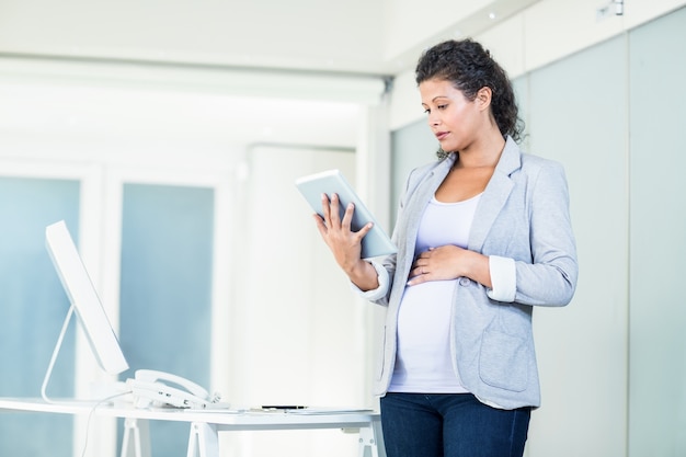 Mulher de negócios bonita que usa o comprimido digital