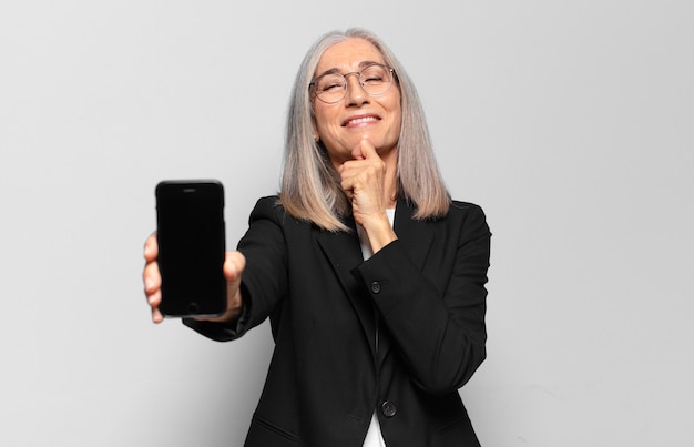 Mulher de negócios bonita sênior com um telefone inteligente.