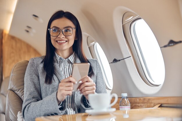 Mulher de negócios bonita sorridente feliz em jato particular