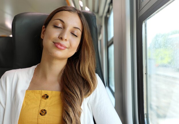 Mulher de negócios cansada dormindo sentada no trem após um dia de trabalho