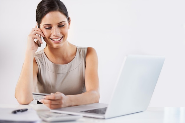 Foto mulher de negócios cartão de crédito e chamada telefônica para serviços bancários comércio eletrônico e pagamento para compras on-line laptop sorriso ou trabalhador feliz falando em smartphone para serviço de informações fintech ou aconselhamento de investimento