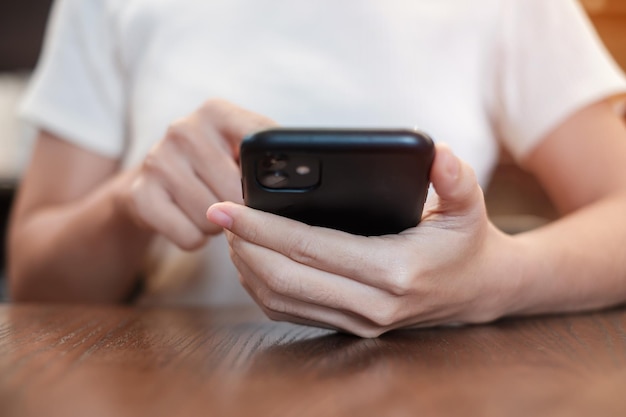 Mulher de negócios casual segurando e usando smartphone para mensagens sms jovem digitando celular touchscreen no café ou tecnologia de estilo de vida de escritório moderno Mídia social e conceito de rede