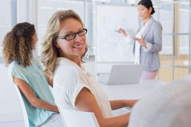 Mulher de negócios casual sorrindo para a câmera durante a reunião