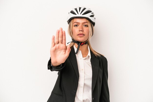 Mulher de negócios caucasiana jovem usando um capacete de bicicleta, isolado no fundo branco, de pé com a mão estendida, mostrando o sinal de stop, impedindo-o.