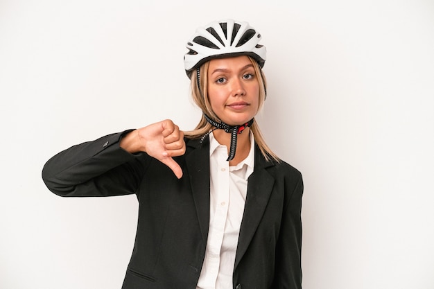 Mulher de negócios caucasiana jovem usando um capacete de bicicleta isolado no fundo branco, mostrando um gesto de antipatia, polegares para baixo. Conceito de desacordo.