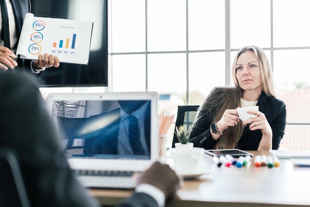 Mulher de negócios caucasiana, sentado e segurando uma xícara de café enquanto ouve uma reunião de consultoria de parceria. Brainstorming novo conceito de investimento financeiro de projeto empresarial.