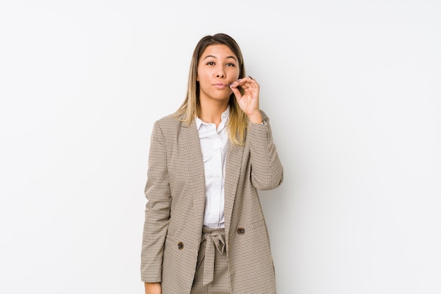 Mulher de negócios caucasiano jovem isolada com os dedos nos lábios, mantendo um segredo.