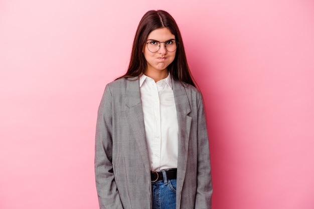 Mulher de negócios caucasiano jovem isolada na parede rosa sopra nas bochechas, tem expressão cansada. Conceito de expressão facial.