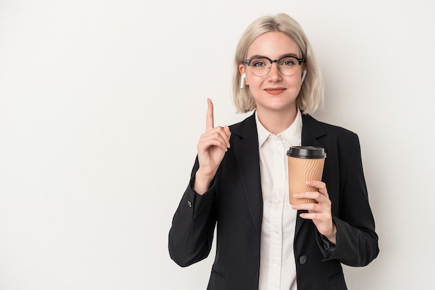 Mulher de negócios caucasiano jovem segurando levar café isolado no fundo branco, mostrando o número um com o dedo.