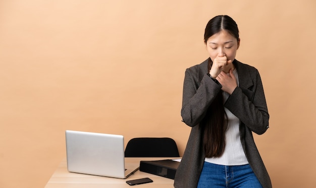 Mulher de negócios chinesa no local de trabalho tossindo muito