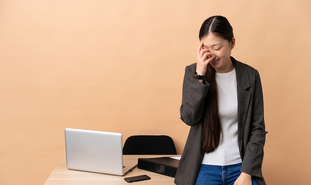 Mulher de negócios chinesa rindo no local de trabalho