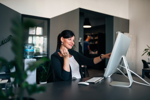 Mulher de negócios com computador touchscreen no escritório.