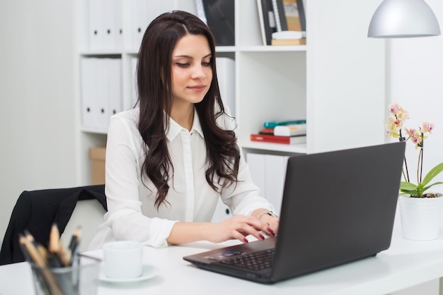 Mulher de negócios com notebook no local de trabalho do escritório