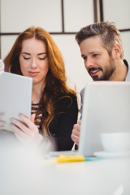 Mulher de negócios com o colega usando laptop