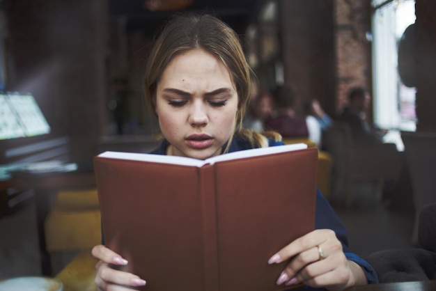 Mulher de negócios com o livro nas mãos do café estilo de vida da xícara de café