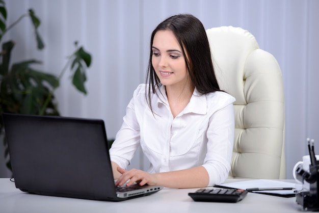 Mulher de negócios com o notebook no escritório.