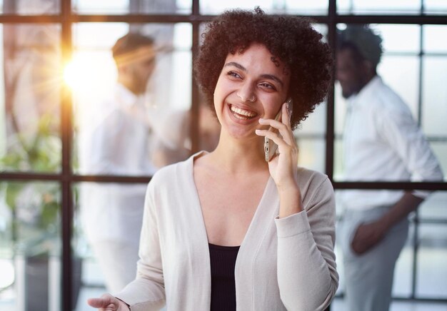 Foto mulher de negócios com telefone num escritório moderno