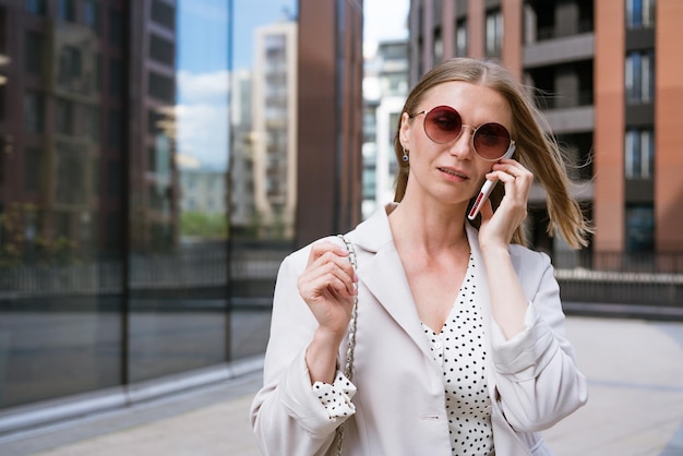 Mulher de negócios com telefone perto do escritório retrato de uma bela menina sorridente