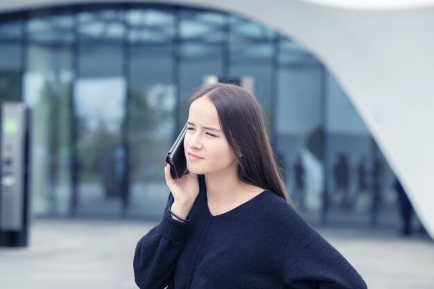 Mulher de negócios com telefone perto do escritório