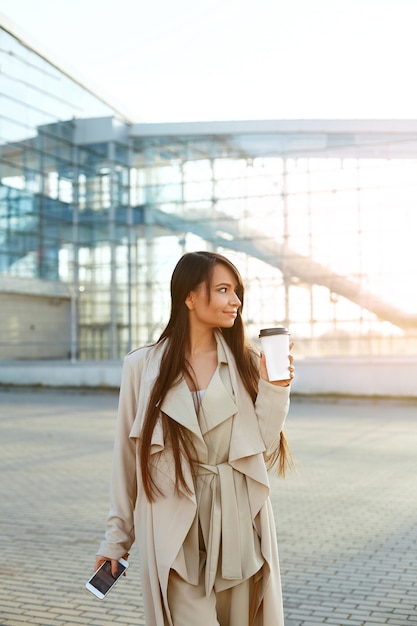 Mulher de negócios com um café e um telefone