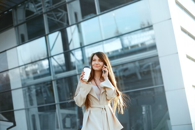 Mulher de negócios com um café e um telefone