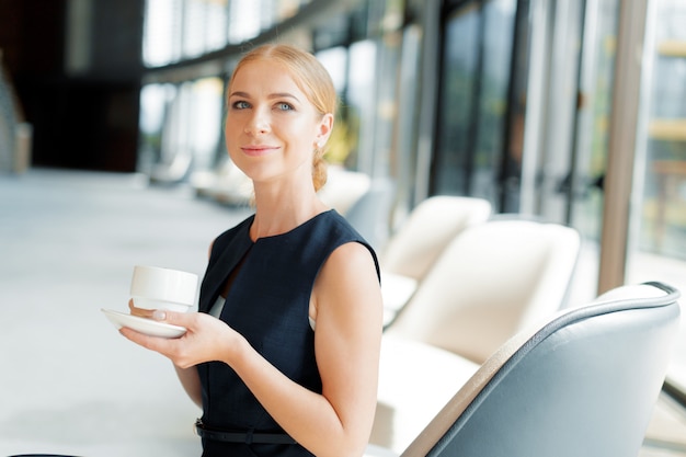 Mulher de negócios com uma xícara de café ou chá