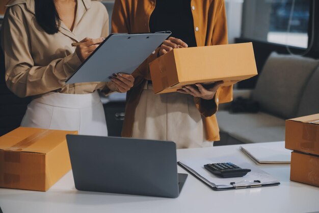 Mulher de negócios começa uma pequena empresa e empresárias bem-sucedidas de PME mulher asiática hoding boxs trabalha em casa entregando encomendas on-line conceito de entrega e embalagem de PME