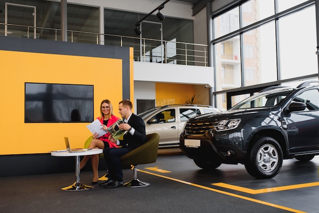 Mulher de negócios compra um carro em uma concessionária.