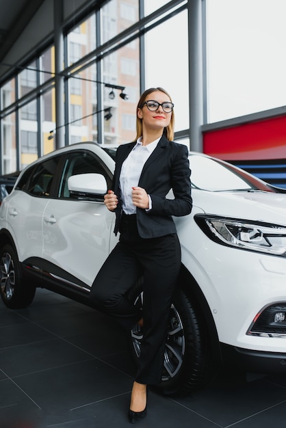 Foto mulher de negócios compra um carro em uma concessionária.