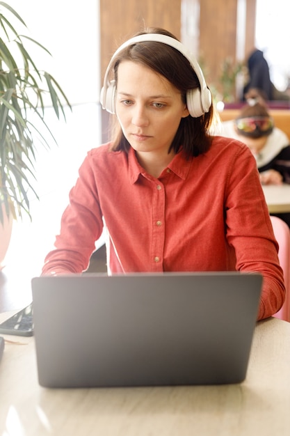 Foto mulher de negócios confiante com um laptop, trabalhando em uma sala de coworking ou no escritório, mulher de óculos