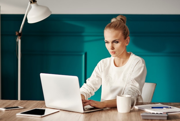 Mulher de negócios confiante digitando no teclado do laptop