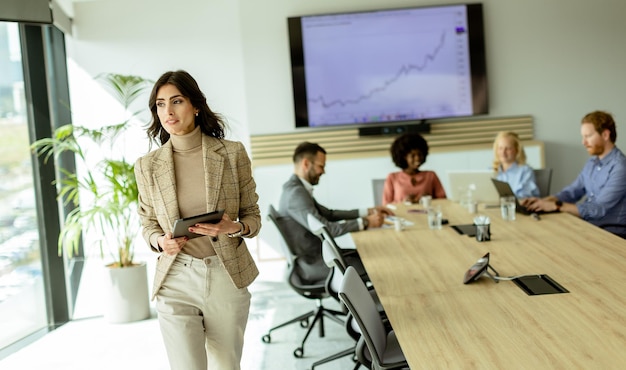 Foto mulher de negócios confiante liderando uma reunião estratégica em um escritório moderno ao meio-dia