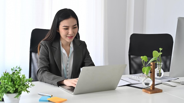 Mulher de negócios confiante trabalhando com um laptop no escritório.