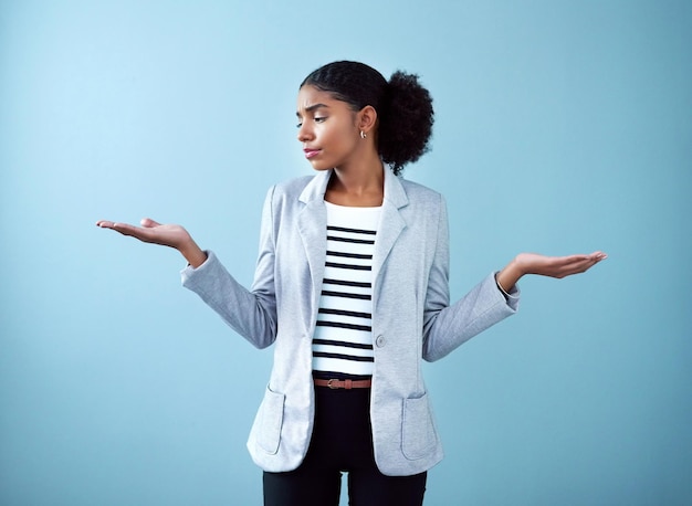 Mulher de negócios corporativa negra profissional fazendo um gesto com a mão para escolha de decisão e equilíbrio em pé contra um fundo de estúdio azul sozinho Um gerente africano escolhendo entre ideias