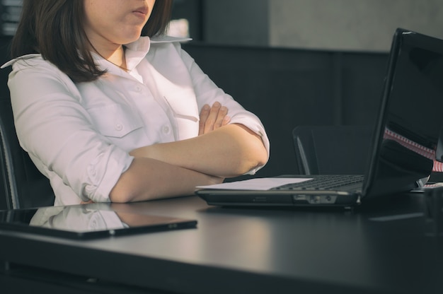 Mulher de negócios cruzou os braços na mesa