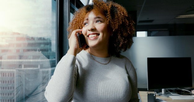 Mulher de negócios de chamada telefônica e janela de escritório para conversa com vista da cidade enquanto feliz e falando Empreendedor com smartphone para comunicação de rede ou proposta de negócio com sorriso