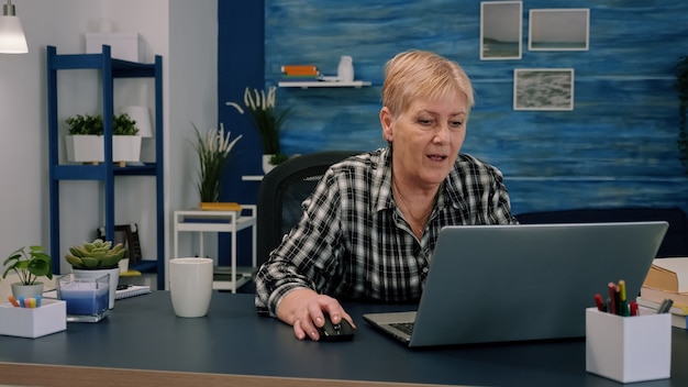 Mulher de negócios de meia-idade trabalhando em um laptop digitando dados financeiros