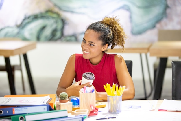 Mulher de negócios de raça mista casual bem-sucedida trabalhando no laptop no local de trabalho