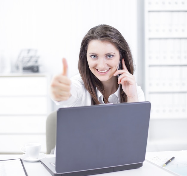 Mulher de negócios de sucesso mostrando o polegar no local de trabalho. Foto com espaço de cópia