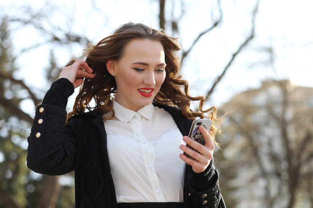 Mulher de negócios de terno ao ar livre com um telefone celular