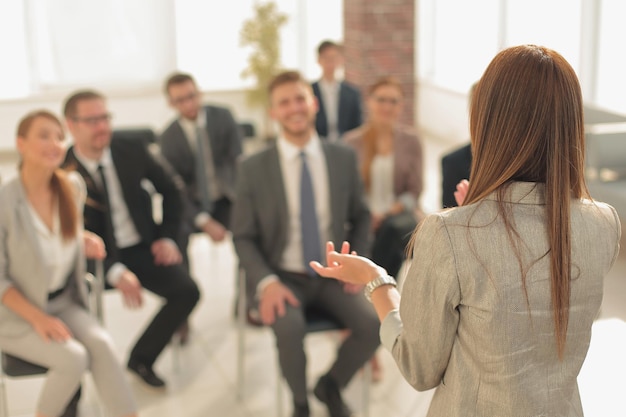 Mulher de negócios de visão traseira realiza uma reunião de trabalho com o fundo de negócios da equipe de negócios