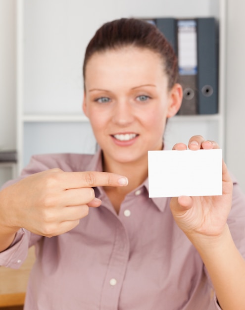 Mulher de negócios deslumbrante apontando para um cartão