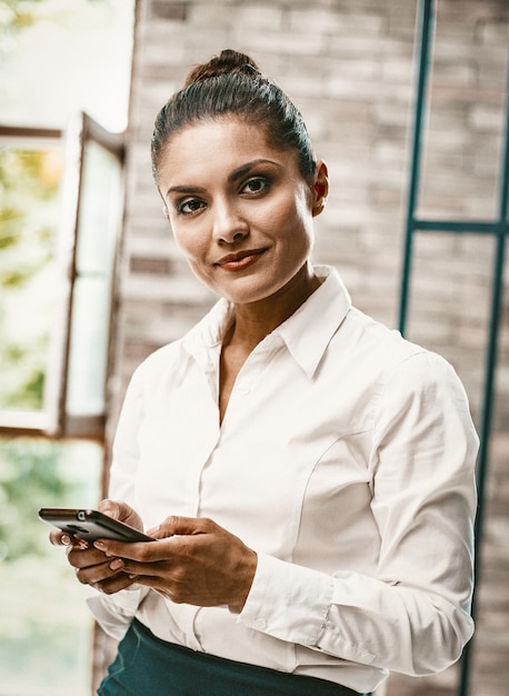 Mulher de negócios, digitando mensagens de texto no telefone inteligente