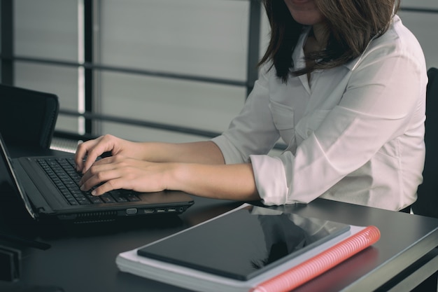 Mulher de negócios, digitando no teclado do laptop