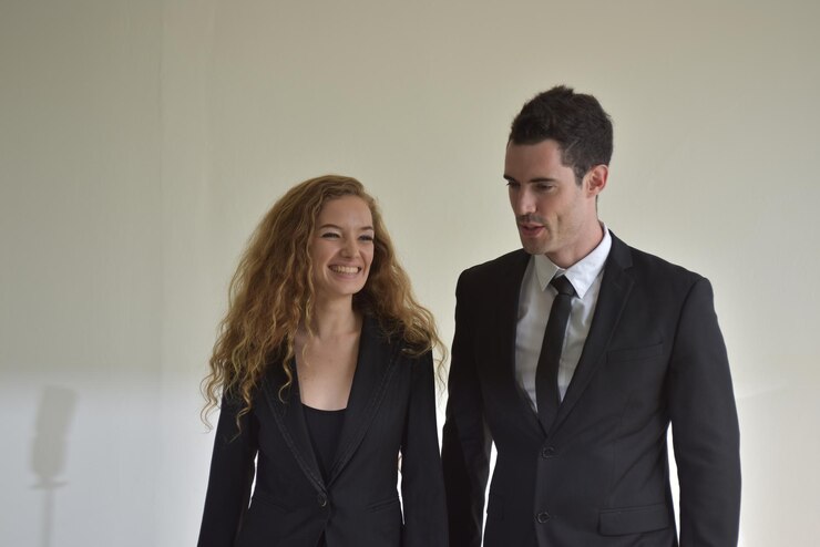 Foto mulher de negócios e homem de negócios a falar contra a parede.