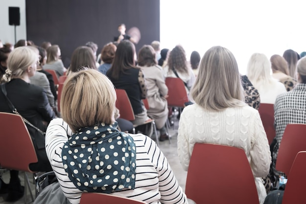 Mulher de negócios e pessoas ouvindo na imagem horizontal da conferência