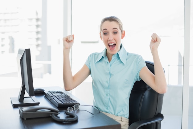 Mulher de negócios elegante aplaudindo sentado em sua mesa